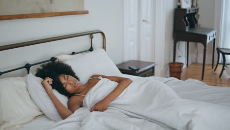 Curly-woman-sleeping-bed-at-morning.-Black-skin-lady-napping-home-laying-pillow