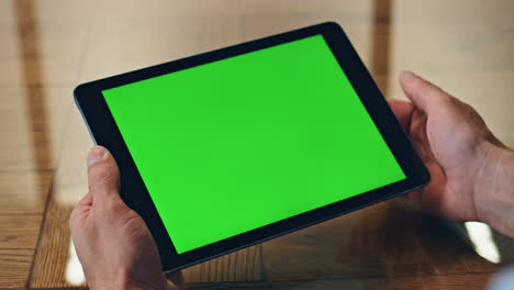 Man-hand-touching-green-tablet-screen-indoor-closeup.-Manager-using-computer