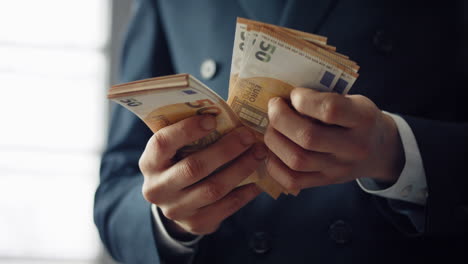 Businessman-counting-euro-bills-close-up.-Man-hands-holding-european-currency.