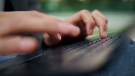 Man-hands-typing-keyboard-at-city-closeup.-Unknown-student-using-laptop-macro