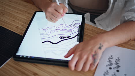 Artist-hand-creating-pad-sketch-cozy-place-closeup.-Woman-zooming-graphic-tablet