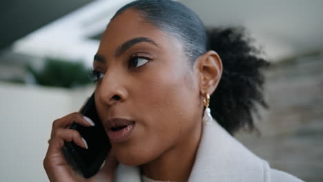 Closeup-african-american-talking-phone-on-street.-Serious-businesswoman-calling