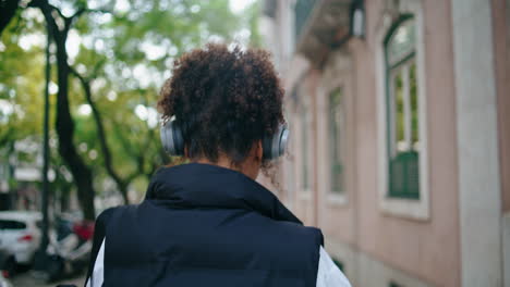 Frau-Beim-Gehen-Hört-Musik-über-Kopfhörer-Aus-Nächster-Nähe.-Afrikanisches-Mädchen-Mit-Kopfhörern