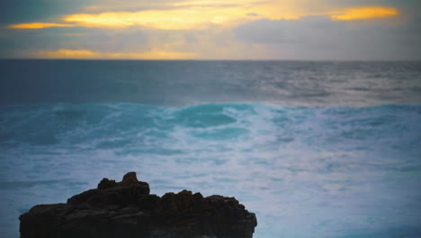 Ocean-hitting-coastline-rock-in-early-morning-closeup.-Beautiful-evening-seaside