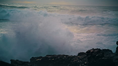 Foaming-waves-breaking-coastline-stones-close-up.-Powerful-ocean-rolling-shore