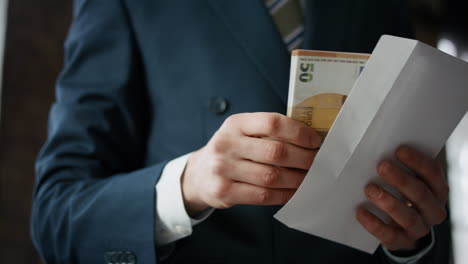 Businessman-taking-euro-envelope-indoors-close-up.-Manager-received-bribe.