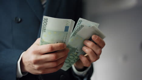 Hands-holding-european-currency-close-up.-Business-man-counting-euro-banknotes.