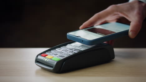 Bargeldloses-Bezahlen-Mit-Dem-Smartphone-An-Einem-Modernen-Bankterminal-Im-Innenbereich,-Nahaufnahme.