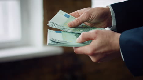 Man-counting-hundred-bills-euro-close-up.-Male-hands-holding-european-currency.