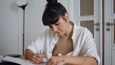 Mujer-Tranquila-Dibujando-Bolígrafo-En-La-Oficina-Remota-De-Cerca.-Tatuador-Creando-Boceto