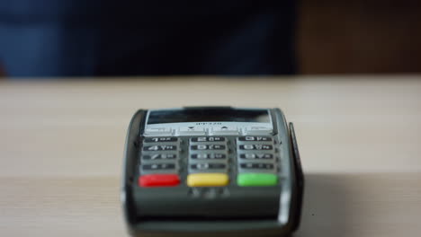 Hands-making-contactless-payment-with-credit-card-at-machine-terminal-close-up.