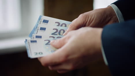 Man-counting-twenty-euros-close-up.-Bankrupt-businessman-calculating-money-cash.