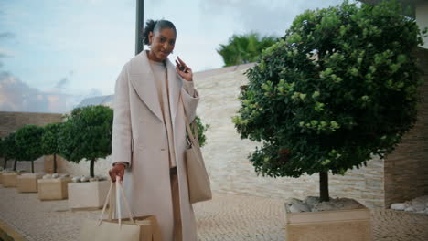 Happy-woman-walking-shopping-bags-on-street.-Smiling-african-american-enjoying