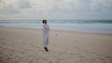 Sad-woman-go-ocean-beach-on-cold-winter-day.-Lonely-pensive-tourist-watch-waves