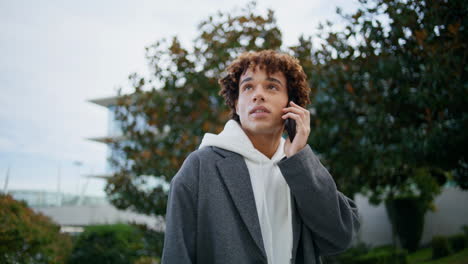 Calm-hipster-speaking-smartphone-outdoors-closeup.-Young-man-making-phone-call