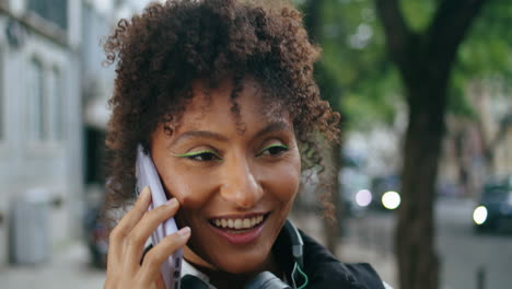 Mujer-Feliz-Hablando-Con-Teléfono-Inteligente-En-Un-Paseo-Por-La-Ciudad-De-Cerca.-Niña-Africana-Llama-Al-Aire-Libre