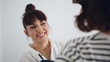 Smiling-tattooist-working-with-client-at-home.-Happy-woman-talking-to-customer