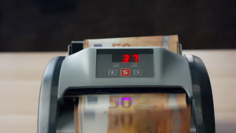 Electronic-cash-counting-machine-with-euro-bills-close-up.-Counter-calculating