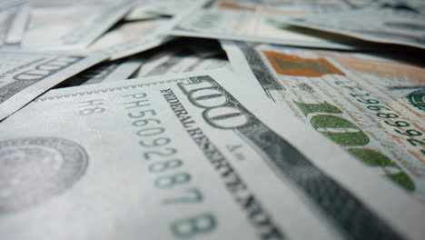 Macro-view-hundred-dollars-bills-scattered-on-surface.-Heap-of-american-currency