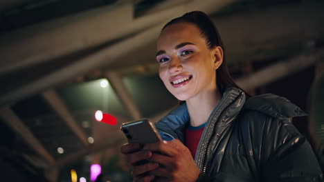 Smiling-girl-looking-smartphone-at-evening-city-close-up.-Woman-browsing-content
