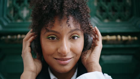 Portrait-woman-wearing-headphones-outdoors.-Girl-using-earset-to-listen-music.