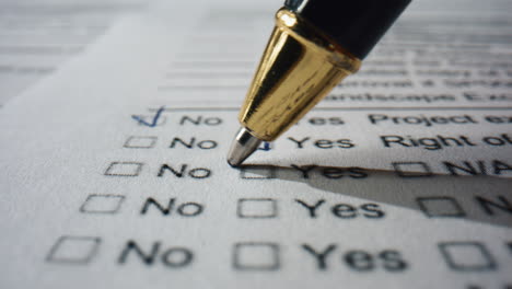Closeup-hand-filling-questionnaire-on-paper.-Ballpoint-writing-marks-on-document