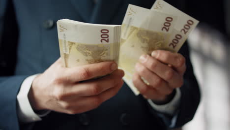 Hands-counting-cash-european-currency-indoors-closeup.-Man-calculating-banknotes