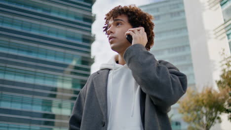 Calling-teen-waiting-at-business-district-close-up.-Serious-guy-looking-around