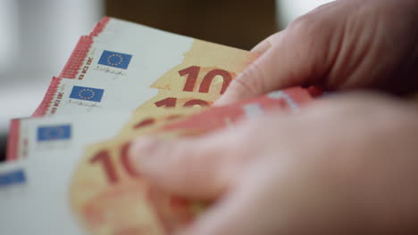 Hands-calculating-euro-cash-denomination-of-ten-close-up.-Worker-counting-money.