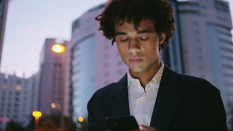Worried-businessman-reading-smartphone-at-night-street.-Young-man-looking-screen