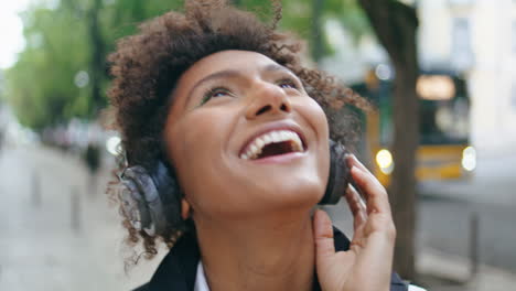 Woman-wearing-headphones-dancing-along-on-city-street-closeup.-Girl-in-headset