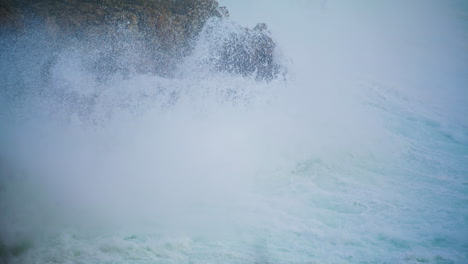 Violent-ocean-waves-crashing-wild-cliff-closeup.-Seashore-storm-crashing-rocks