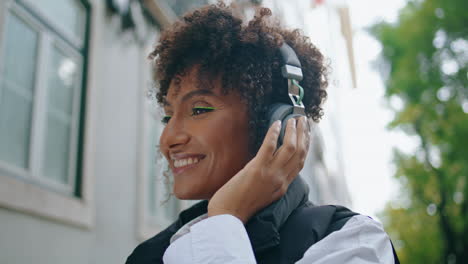 Girl-listening-music-earphones-on-street-closeup.-Woman-enjoying-song-vertical
