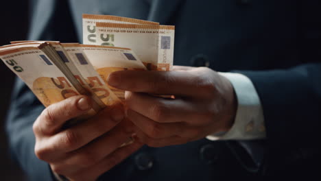 Closeup-hands-counting-money-denomination-of-fifty-euro.-Man-calculating-cash.
