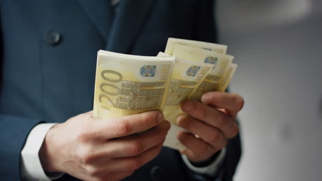 Pack-euro-bills-counting-by-unknown-business-man-closeup.-Hands-calculating-cash