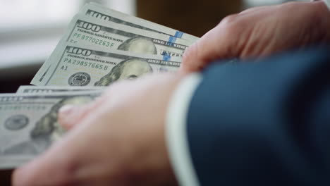 Banker-hands-counting-american-currency-denomination-of-hundred-dollars-close-up