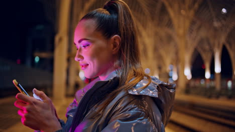 Attractive-woman-using-smartphone-for-messaging-at-night-gothic-city-close-up.
