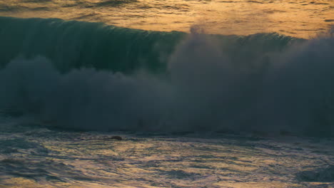 Sea-wave-breaking-shore-in-early-morning-closeup.-Powerful-surf-foaming-swelling