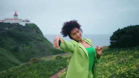 Contemporary-dancer-moving-hands-gracefully-on-green-flowers-hills-close-up.