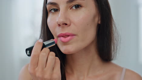 Portrait-model-applying-lipstick-home.-Happy-lady-making-makeup-using-lip-care
