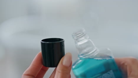 Woman-hands-pouring-mouthwash-in-cap-close-up.-Unknown-lady-holding-dental-rinse