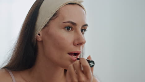 Focused-model-applying-lipstick-at-home.-Woman-colouring-lips-enjoying-makeup