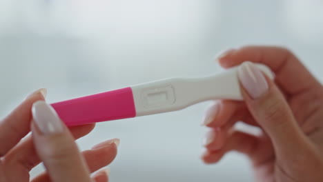 Girl-hands-waiting-pregnancy-test-result-at-home.-Lady-looking-empty-test-kit