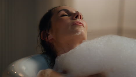 Relaxed-woman-bathing-evening-room-closeup.-Carefree-lady-enjoying-spa-procedure