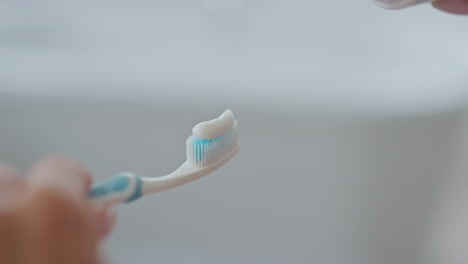 Dame-Hand-Anwendung-Zahnpasta-Pinsel-Drinnen-Nahaufnahme.-Zahnhygiene-Gesundheitswesen
