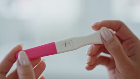 Woman-fingers-pregnancy-test-making-indoor-closeup.-Lady-looking-negative-result