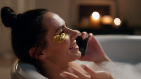 Laughing-model-talking-smartphone-in-bathtub-closeup.-Happy-girl-laying-bath