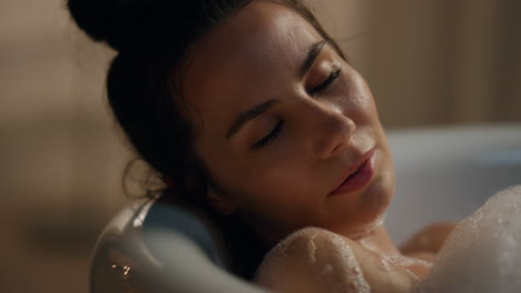 Romantic-girl-washing-body-in-foam-bathtub-closeup.-Lady-lying-at-bathroom-alone