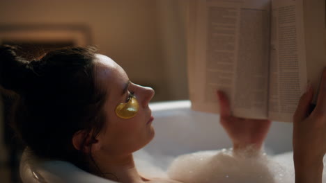 Spa-model-reading-book-chilling-foam-bath-closeup.-Woman-enjoying-hot-bathtub