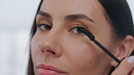 Confident-model-painting-lushes-home-pov-video.-Brown-eyed-lady-preparing-makeup